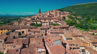 Umbria 'nın pitoresk bir ortaçağ kasabası olan Spello' nun çarpıcı hava manzarası. Antik taş mimarisi, dar sokaklar ve Subasio dağının yamaçlarına kurulmuş Roma duvarları..