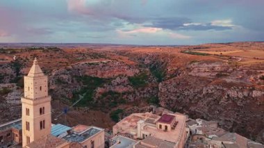 Matera 'nın gün batımındaki görüntüsü, Basilicata, İtalya. Altın saat ışığı, Bruna 'lı Maria Santissima Katedrali' ni ve antik gökyüzü boyunca uzanan tarihi Sassi konutlarını aydınlatıyor..