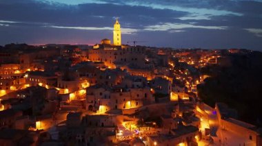 Matera 'nın gece havadan görünüşü, İtalya. Bruna ve Sant Eustachio 'lu Maria Santissima' nın Roma mimarisi Basilicata 'daki antik Sassi konutlarının üzerinde yer almaktadır..