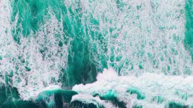 Güçlü beyaz Atlantik dalgalarının yukarıdan aşağıya karanlık volkanik kayalara çarpması. Karışık köpük desenleri ve Sao Miguel kıyısında derin mavi su, Azores, Portekiz