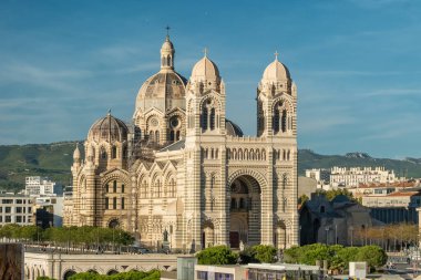 Yollara, ağaçlara ve şehir mimarisine tepeden bakan yüksek bir sokak seviyesinden Marsilya Katedrali 'nin kentsel manzarası.