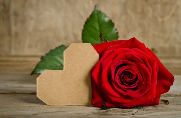 Красная роза с валентинкой для текста на деревянном фоне — стоковое фото