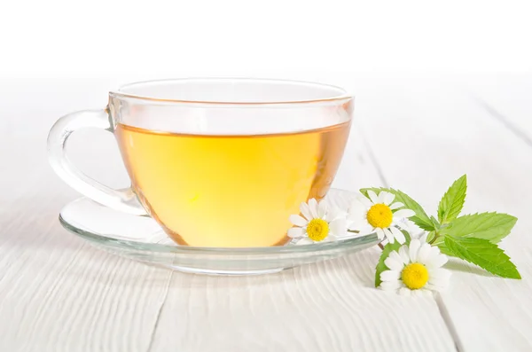 Beker van medicinale kamille thee op de houten tafel — Stockfoto