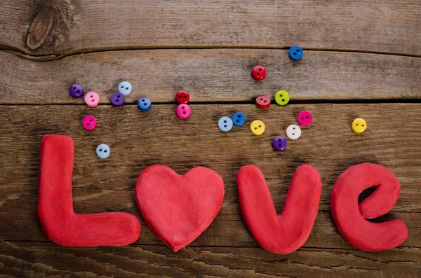 The word LOVE  and  colorfull buttons on wooden background — Stock Photo, Image