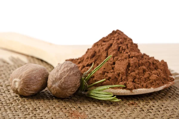 Frutos secos con una ramita de romero y cacao en polvo en la madera — Foto de Stock