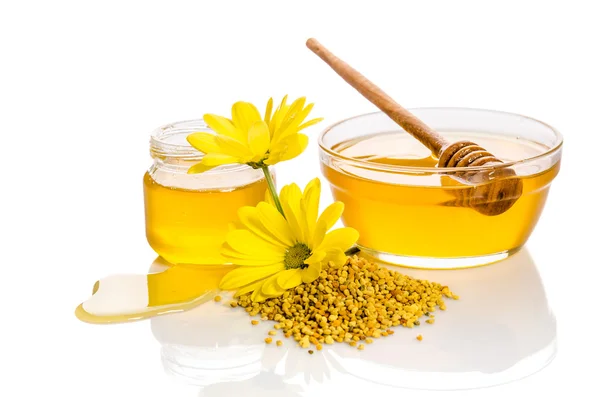 La ciotola e il barattolo di miele vicino a un mucchio di polline e fiore i — Foto Stock