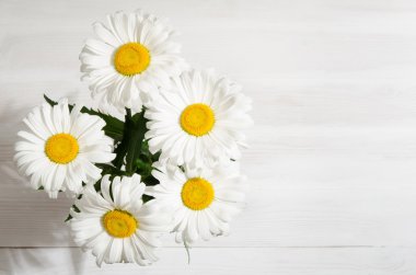 hafif ahşap masa üzerinde papatya buketi