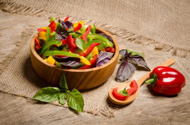 dolmalık biber ve fesleğen ahşap tabl üzerinde ahşap bir kase salata