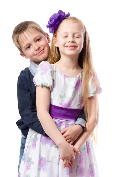 Niño abrazando a una chica sobre un fondo blanco — Foto de Stock