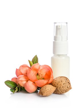 Pembe çiçek üzerinde beyaz izole şişeyle yüz kremi