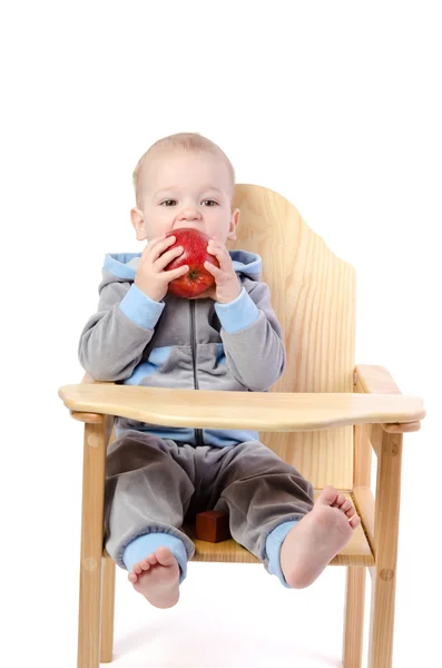 红苹果的小男孩坐在孩子们的椅子上 w 孤立 — 图库照片