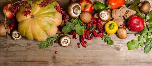 Vegetables, nuts, berries and  fruits over old wooden table. — Stock Photo, Image