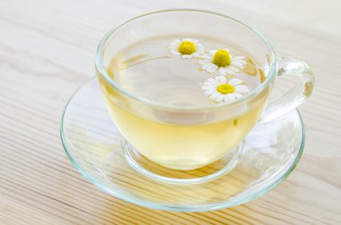 Ahşap masa üzerinde tıbbi papatya çayı fincan