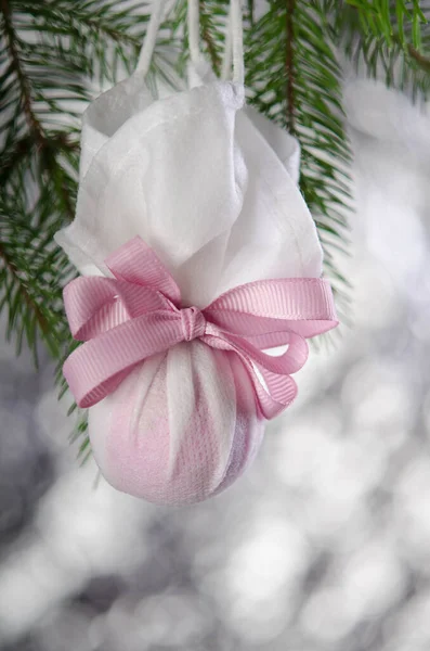 Bola Navidad Envuelta Una Máscara Médica Con Una Cinta Rosa —  Fotos de Stock