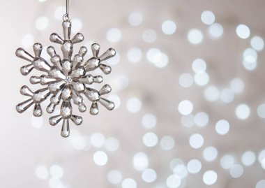 Şeffaf oyuncak kar tanesi. Bokeh. Gümüş Noel ışıkları. Noel süslemesi