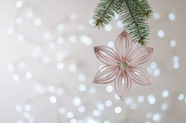 Pembe çiçek bir Noel ağacının dalında asılı. Bokeh. Noel süslemesi