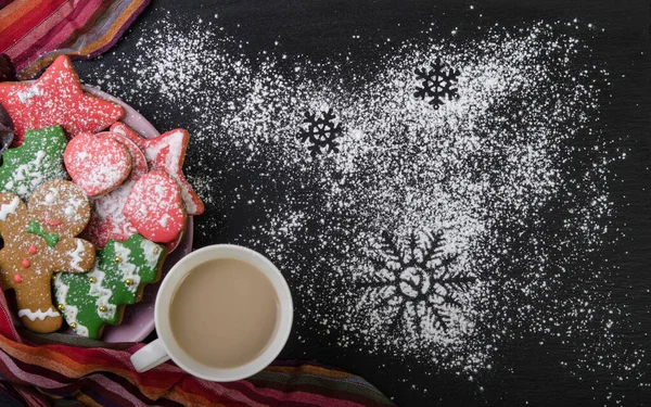 Multi-colored gingerbread cookies in a bowl on a black top. Christmas decoration.