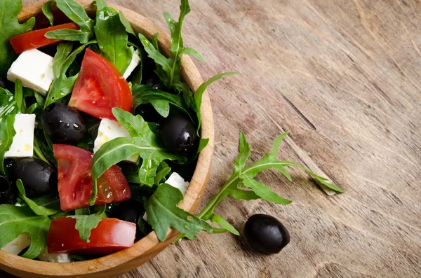 Grekisk sallad i en trä salladsskål på bordet — Stockfoto