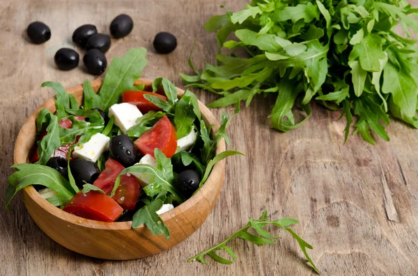 Grekisk sallad i en trä salladsskål på bordet — Stockfoto