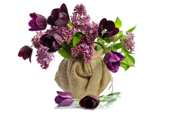 Beautiful bouquet of tulips with sprigs of lilac in a vase isola — Stock Photo, Image