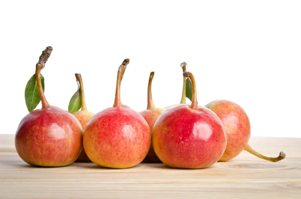 Small pears and leaves in a grouping on wooden table — Stock Photo, Image