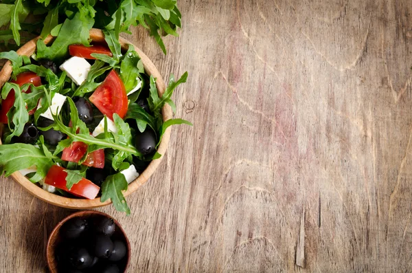 Греческий салат в деревянном салате на столе — стоковое фото