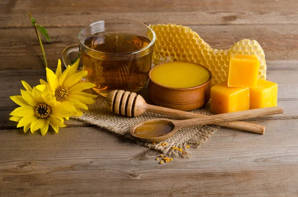 Natura morta da tazza di tè, miele, cera e granuli di polline Foto Stock