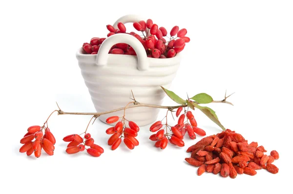 Porcelain basket with berberries near heap of goji berries  isol — Stock Photo, Image