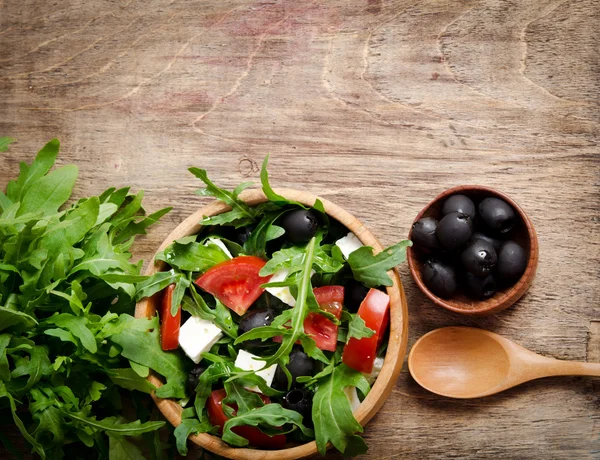 Grekisk sallad i en trä salladsskål på bordet — Stockfoto