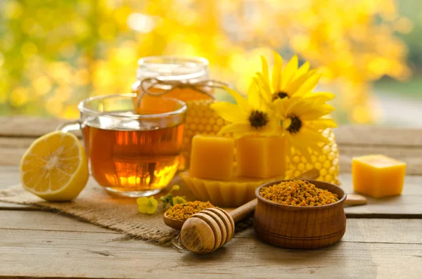 Nature morte de tasse de thé, citron, miel, cire, nids d'abeilles et — Photo