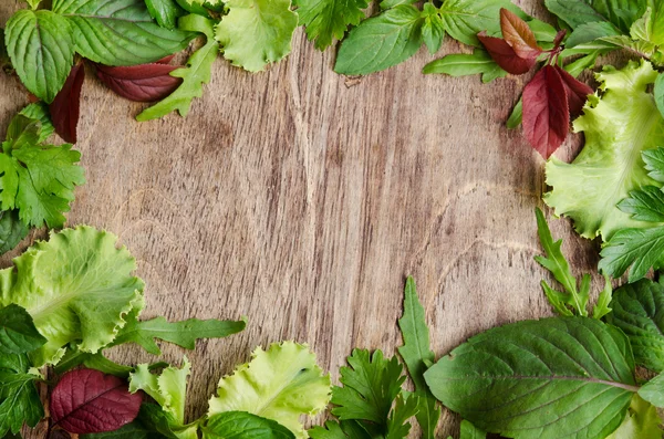 在木制背景的帧上的新鲜绿色沙拉 — 图库照片