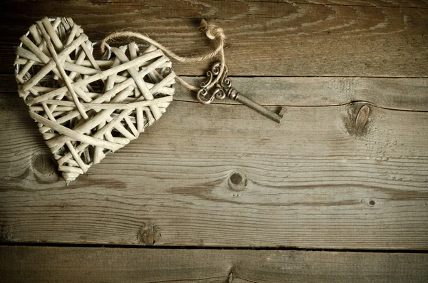 Rieten hart handgemaakt met de toets liggend op een houten voet — Stockfoto