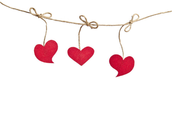 Three Red fabric hearts hanging on the clothesline isolated on w