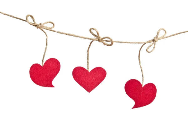 Trois coeurs en tissu rouge suspendus sur la corde à linge isolé sur w — Photo