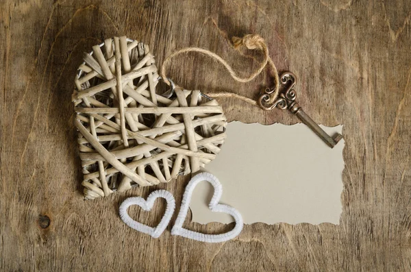 Corazón de mimbre hecho a mano con la llave y dos corazones pequeños acostados en — Foto de Stock