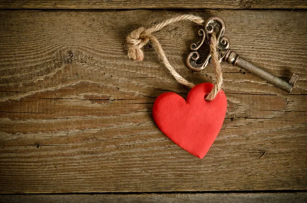 Corazón hecho a mano con llave juntos acostados en una tabla de madera — Foto de Stock