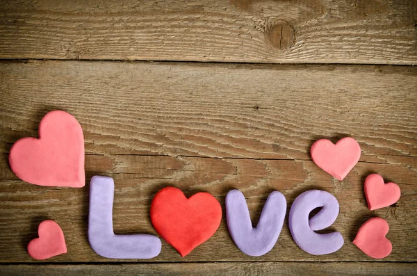 Palavra Composição do amor na superfície da placa de madeira e muitos coração — Fotografia de Stock