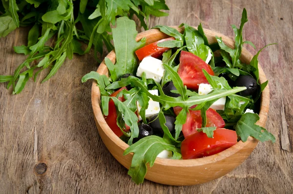 Grekisk sallad i en trä salladsskål på bordet — Stockfoto