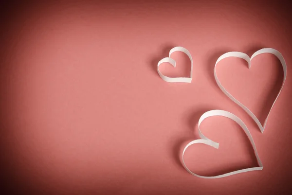 Three hearts of white paper lying on a red background — Stock Photo, Image