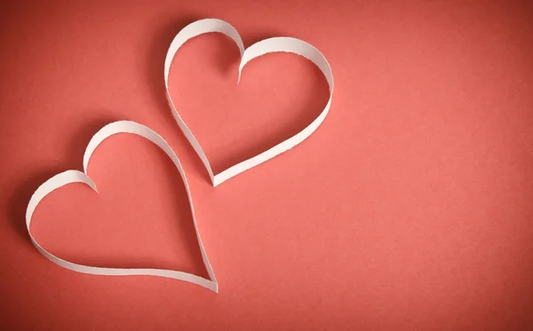 Zwei Herzen aus weißem Papier liegen auf rotem Hintergrund — Stockfoto