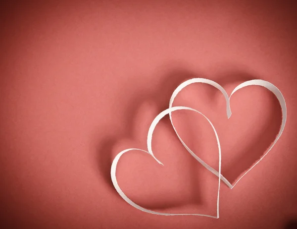 Two hearts of white paper together lying on a red background — Stock Photo, Image
