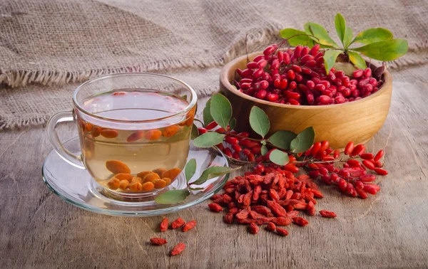 Годзи свежий антиоксидантный чай в стеклянной чашке и ягоды из дерева — стоковое фото