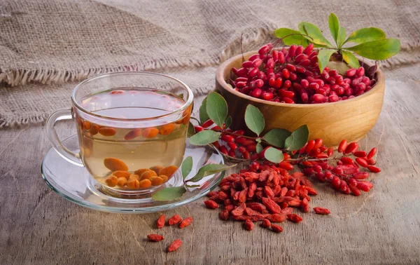 Goji taze antioksidan çay barberries içinde ahşap ve cam Kupası