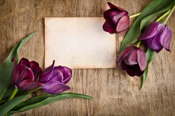 La vieille carte et les tulipes fraîches des deux coins reposent sur le bois — Photo