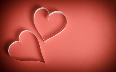 Beyaz kırmızı bir arka plan üzerinde yalan kağıt iki kalp