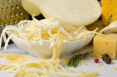 rendelenmiş peynir ve baharat çevresinde bir kase