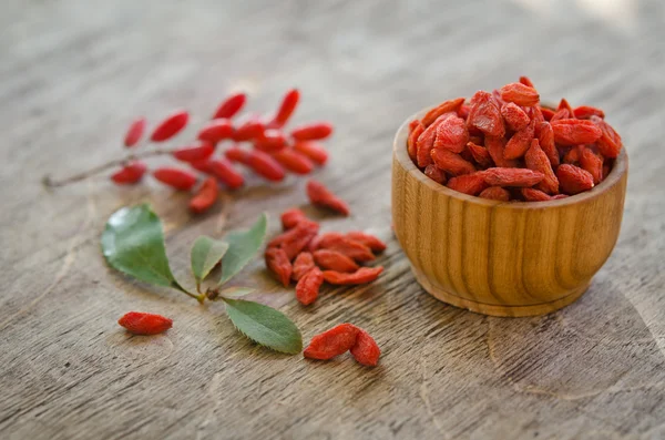 Baga e goji bagas em fundo de madeira — Fotografia de Stock