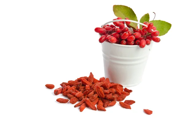 Metal bucket with barberries near heap of goji berries  isolated — Stock Photo, Image
