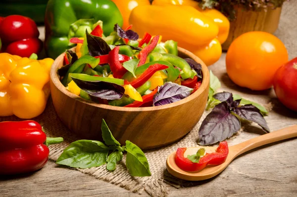 Ensalada de pimiento y albahaca en un tazón de madera y verduras —  Fotos de Stock