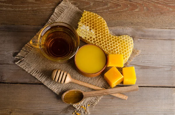 Stilleven van kopje thee, honing, wax en honingraten op houten — Stockfoto